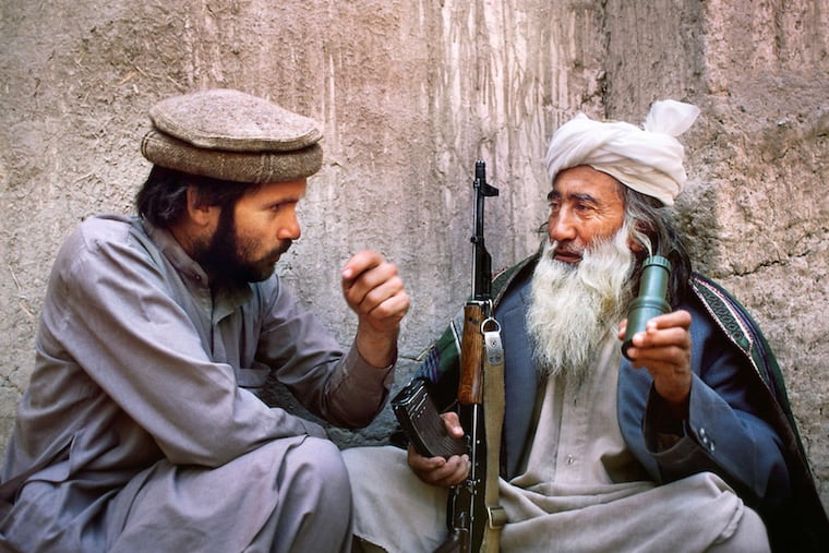 Photographer Steve McCurry (left) in a 1982 self-portrait with an Afghan man. The Michener exhibit spans the Darby native's 40-year focus on the country.