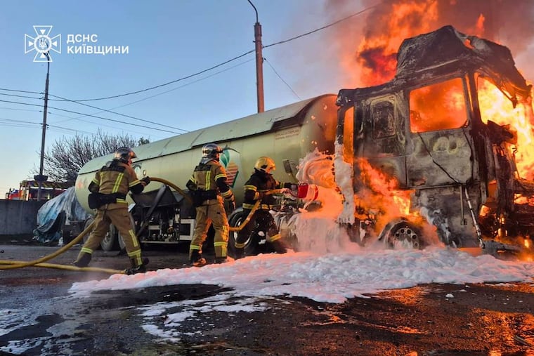 In this photo, provided by the Ukrainian Emergency Service, emergency services personnel work to extinguish a fire a vehicle following a Russian drone attack in Kyiv region, Ukraine, Tuesday, May 5, 2026.