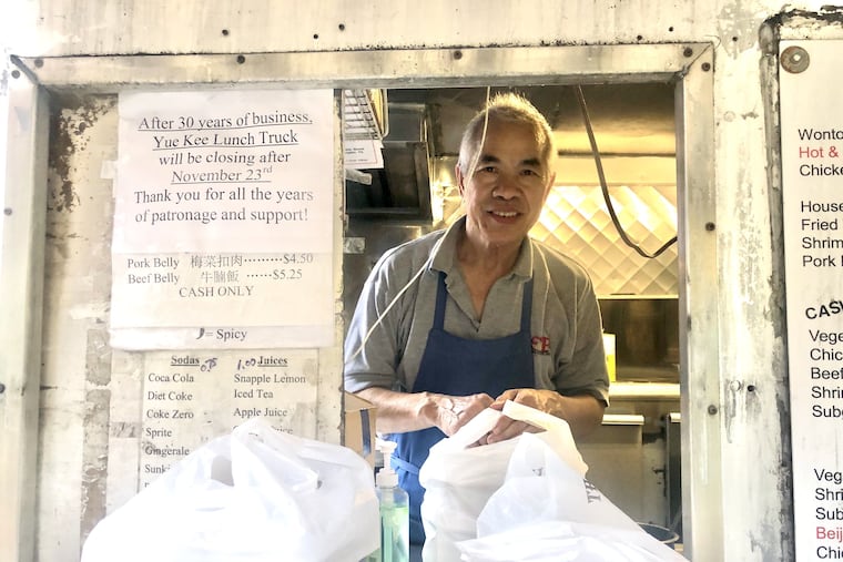 Chef and co-owner Tsz Pong peaks out of the takeout window at Yue Kee, the Chinese food truck he ran with his wife Bi Pang across from Wharton that is closing after 37 years. He removed his mask briefly for the portrait.