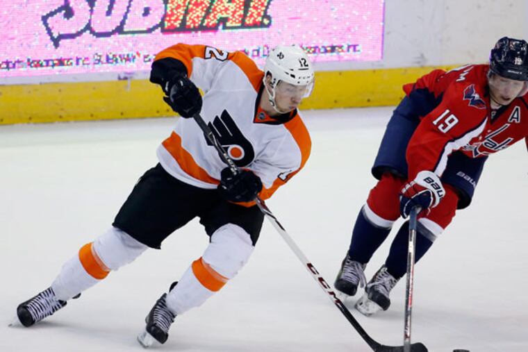 Flyers left wing Michael Raffl (12), from Austria, and Capitals center Nicklas Backstrom (19), from Sweden, go for the puck in the third period of an NHL hockey game, Sunday, Dec. 15, 2013, in Washington. The Capitals won 5-4 in a shootout. (Alex Brandon/AP)