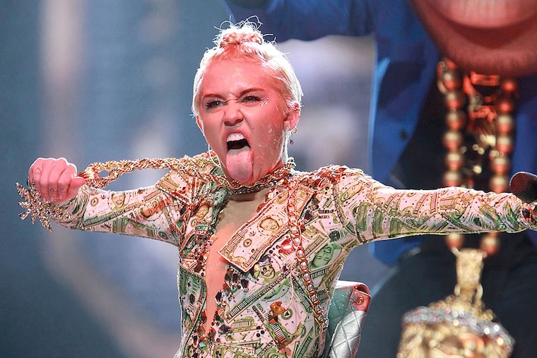 Miley Cyrus treats fans to a signature move Saturday at the Wells Fargo Center.