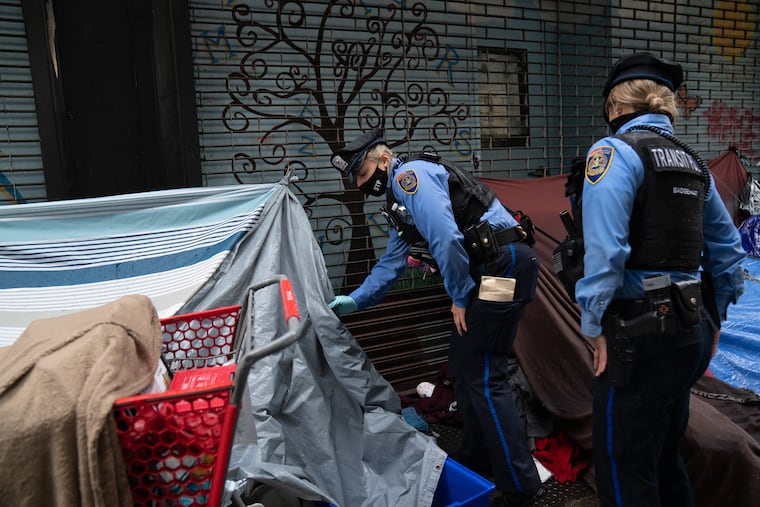 Police Officer Jennifer DellaVecchio, center, and Police Officer G. Fenwick, right, check on a person sleeping in a tent on Kensington Ave., in Philadelphia, Thursday, October 29, 2020. SEPTA recently started a program called "SAVE" that connects social workers and SEPTA police to work together to provide assistance and resources to those who need.