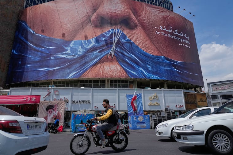 Vehicles drive past a billboard with a graphic showing the Strait of Hormuz and President Donald Trump's sewn lips in a square in downtown Tehran, Iran, on Saturday.