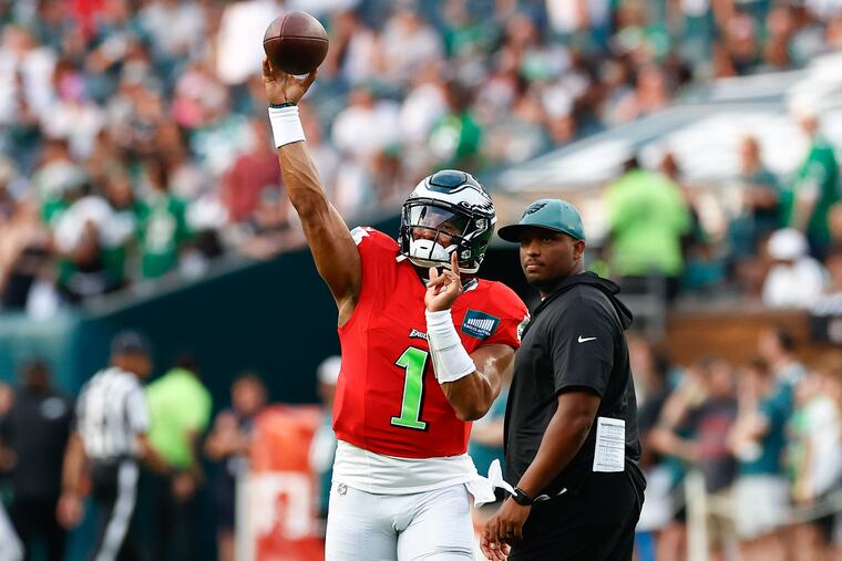 Eagles quarterback Jalen Hurts throws a pass as offensive coordinator Brian Johnson watches during public training camp practice on Aug. 6 at Lincoln Financial Field. Could Hurts and the Birds return to the Super Bowl?