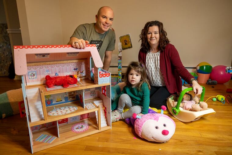 Cosima Fishburn, 2, with parents Monica Sweeney (right) and father Shaun Fishburn in their King of Prussia home on Wednesday morning November 30, 2022.