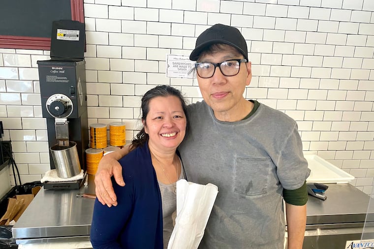 Andre Chin with his wife, Amanda Eap, who holds a wrapped baguette, at Artisan Boulanger Patissier in April 2022.