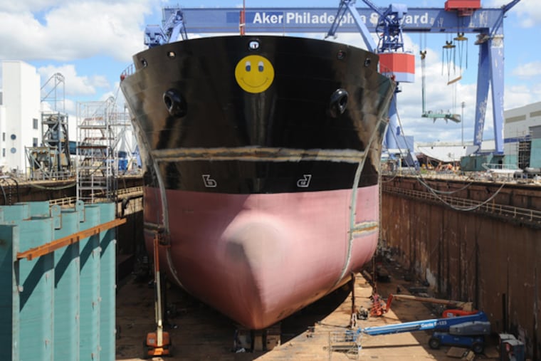 Scene from the Aker Shipbuilding complex: Ship #18, with the Aker trademark smiley face on its bow, under construction in dry dock. (CLEM MURRAY/Staff Photographer)