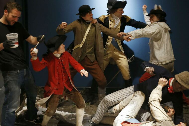 Artist Brett Alexander touches up a tableau showing George Washington breaking up a snowball fight in Harvard Yard.