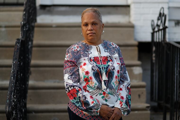 Monique Irvis stands in front of her Southwest Philadelphia home in December 2021. Irvis visits her son's gravesite every year at Christmas, his birthday. Her son was shot and killed in 2007.