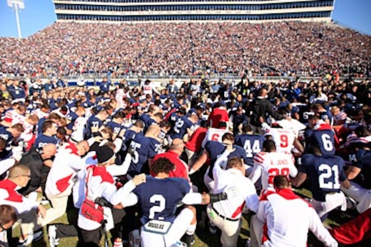 Penn State and Nebraska players pray together before the start of Saturday's game. (David Swanson/Staff Photographer)