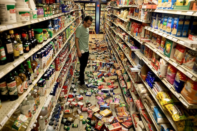 Redwood Valley Market owner Alex Chehada looks at items that fell off the shelves after an earthquake in Redwood Valley, Calif., Wednesday.