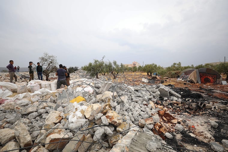 A picture taken on Monday, Oct. 28, 2019 shows Syrians sifting through the rubble at the site of a suspected U.S.-led operation against Islamic State chief Abu Bakr al-Baghdadi the previous day, on the edge of the small Syrian village of Barisha in the country's opposition-held northwestern Idlib province.