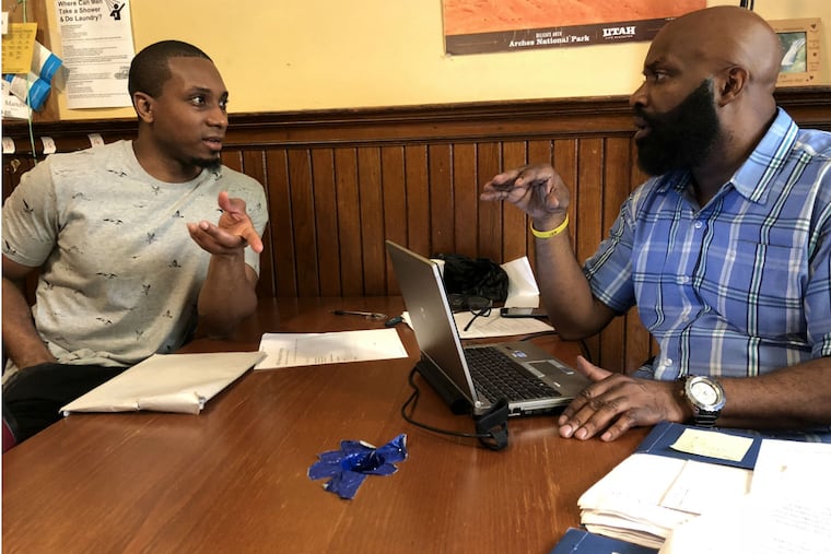 Michael West (left) works with Joe Robinson of the Pennsylvania society to put together West's first real resume. West spent 14 years in prison. He was released on May 3.
