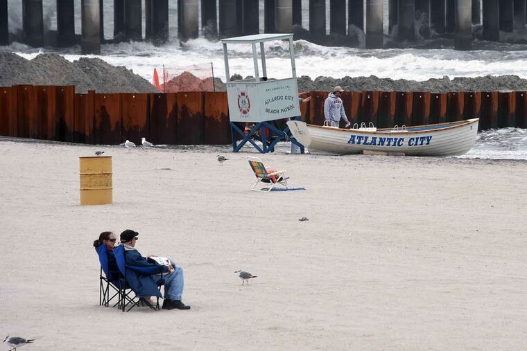 People enjoy the Atlantic City beach on Monday near Resorts and the Taj Mahal casinos as Gov. Christie attended a closed door summit meeting about the future of the gaming town. Story, A1.