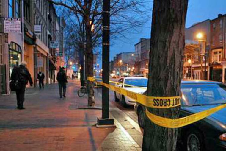 The scene in the 200 block of Market Street before dawn Thursday. Earlier in the morning a man was shot and killed outside the Prive Tapas Restaurant and Lounge in Olde City. (Tom Gralish / Staff Photographer)