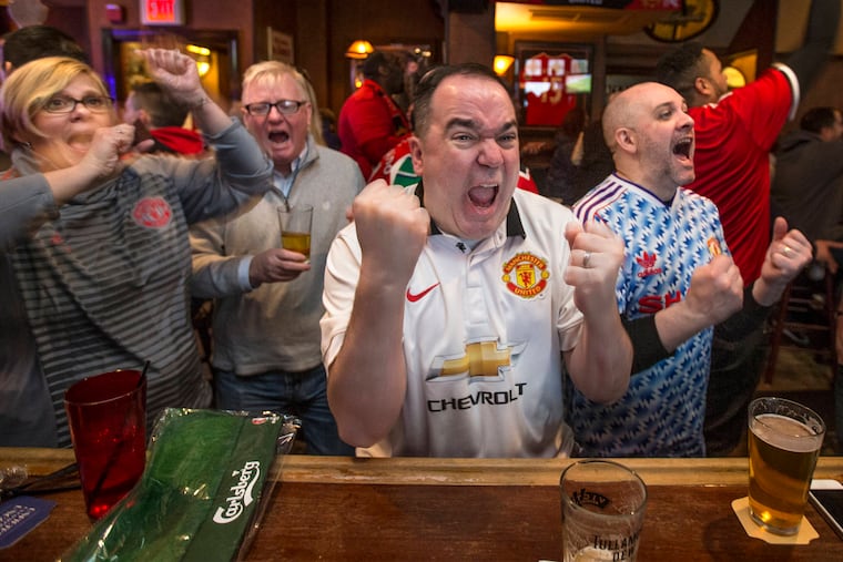 Tom Hoffman (center) of Port Richmond and Laura Lapaugh (left) of Westampton Township, N.J. celebrate at Center City's Black Sheep Pub, as Manchester United scores a goal against Chelsea Sunday morning, February 25, 2018.
