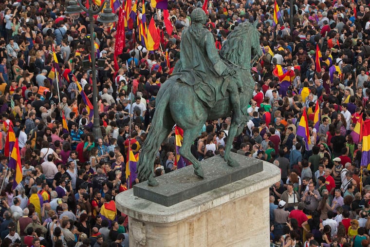 A crowd waves republican flags around the monument of King Charles III in the main square of Madrid after the announcement of abdication by 76-year-old King Juan Carlos.