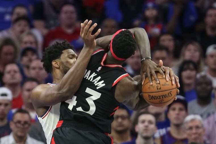 Sixers' Joel Embiid wraps up Raptors' Pascal Siakam during the 4th quarter of Game 3 of the second round of the NBA playoffs at the Wells Fargo Center in Philadelphia, Thursday, May 2, 2019. Sixers beat the Raptors 116-95.