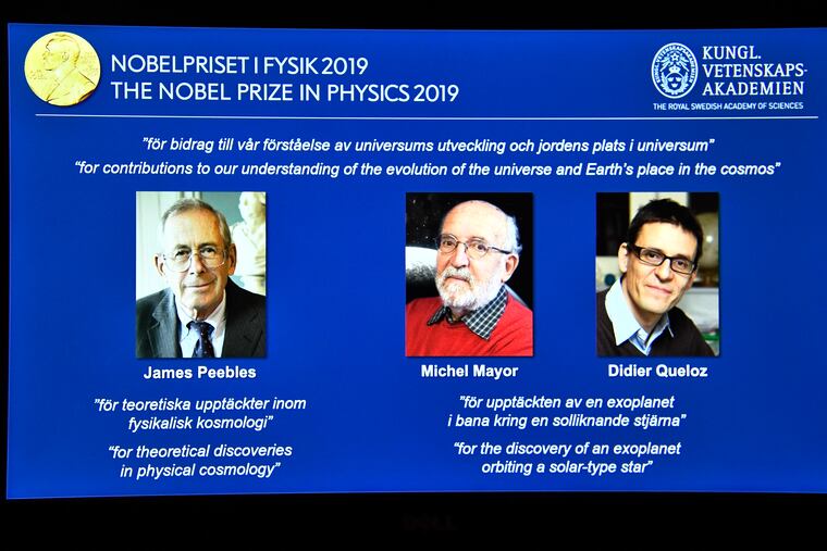A screen displays the portraits of the laureates of the 2019 Nobel Prize in Physics, with left to right, James Peebles, Michel Mayor and Didier Queloz, during a news conference at the Royal Swedish Academy of Sciences in Stockholm, Sweden, on Tuesday Oct. 8, 2019. (Claudio Bresciani / TT via AP)