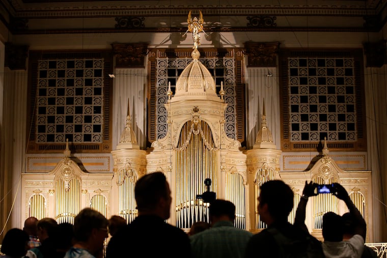 Spectators view newly refurbished Wanamaker pipe organ case from the second level of the Center City Macy's on Saturday. Macy's and Friends of the Wanamaker Organ unveiled the restoration on Saturday.