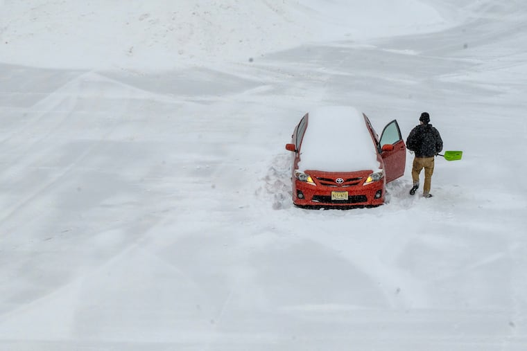 Luis Nova digs his car out of his plowed-in space in an otherwise empty parking lot at the Westmont PATCO station in Haddon Township Sunday, Jan. 25, 2026. Nova left his car there last Friday, and was in Philadelphia all weekend helping friends move and going to a goodbye party. He spent the morning sledding with friends in Clark Park in West Philadelphia. Nova said: “I knew what I was signing up for and was ready. I left all my equipment to get myself out. I spent four years in Rochester, so I have a little experience with this. The only thing I’m missing is the kitty litter I usually keep in case I have to put it under the tires.” Heavy snow bands moved through the region generating snowfall rates of 1 to 2 inches an hour.