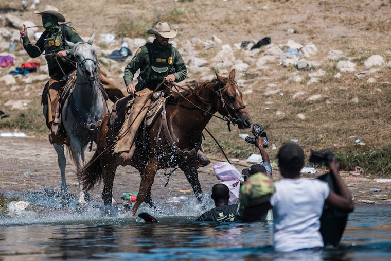 U.S. Customs and Border Protection mounted officers attempt to contain migrants as they cross the Rio Grande from Ciudad Acuña, Mexico, into Del Rio, Texas, on Sunday.