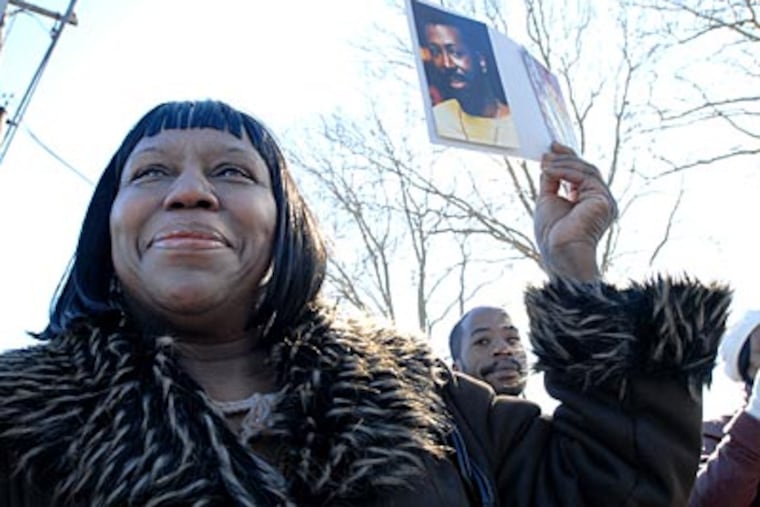 Deborah Satchell of Philadelphia holds up a photo of Teddy Pendergrass as the funeral procession passes by. ( April Saul / Staff Photographer )