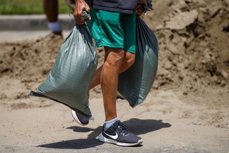 An Algiers resident carries sandbags ahead of Tropical Storm Bertha at Morris FX Jeff Sr. Park in Algiers, New Orleans, Monday, July 20, 2026.