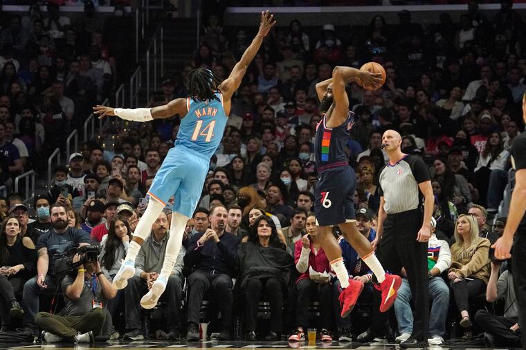 Philadelphia 76ers guard James Harden, right, passes the ball while under pressure from Los Angeles Clippers guard Terance Mann during the first half of an NBA basketball game Friday, March 25, 2022, in Los Angeles. (AP Photo/Mark J. Terrill)
