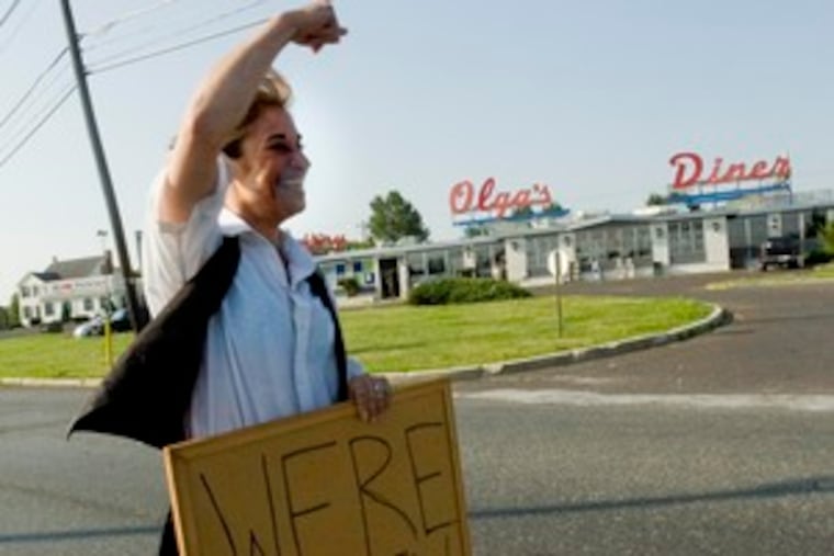 Lisa Saracco, a waitress at Olga's Diner, stands in Marlton Circle to spread the news: The diner, shut down for a week, has reopened.