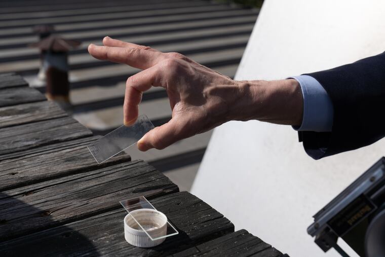 Dr. Donald Dvorin removes a pollen slide on the roof of his office in Mount Laurel last year. His ragweed counts have been "extreme" this season.