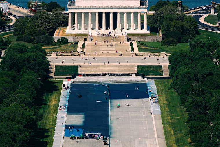 Workers coat the Lincoln Memorial Reflecting Pool in a blue swimming pool surface, covering up a decades-old granite surface, ahead of America 250, Tuesday, May 5, 2026, seen from the Washington Monument in Washington.
