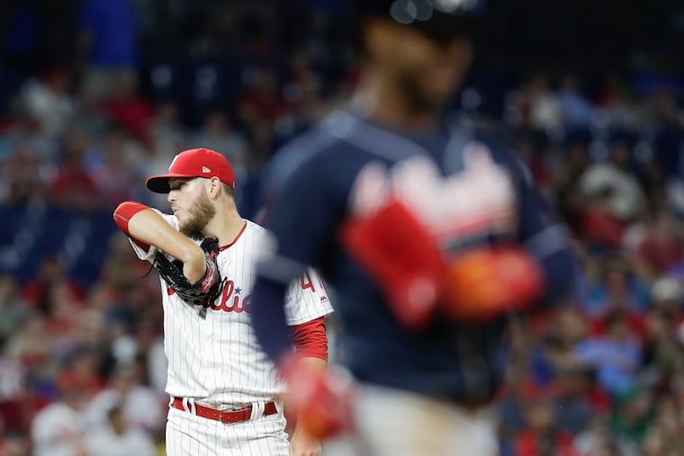 Phillies pitcher Cole Irvin wipes his face after walking Atlanta Braves Ozzie Albies during the sixth-inning on Friday, July 26, 2019 in Philadelphia. The walk scored Braves Ender Inciarte.