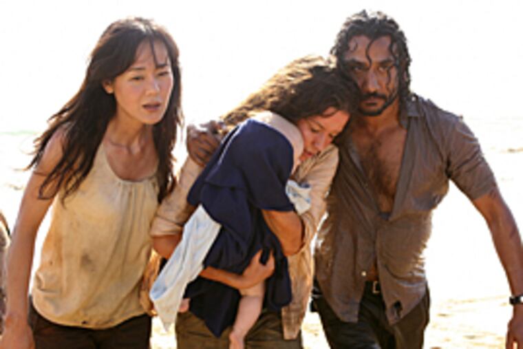 Yunjin Kim, Evangeline Lilly, holding a baby, and Naveen Andrews are shown in a scene from the season finale of "Lost." (AP/ABC)