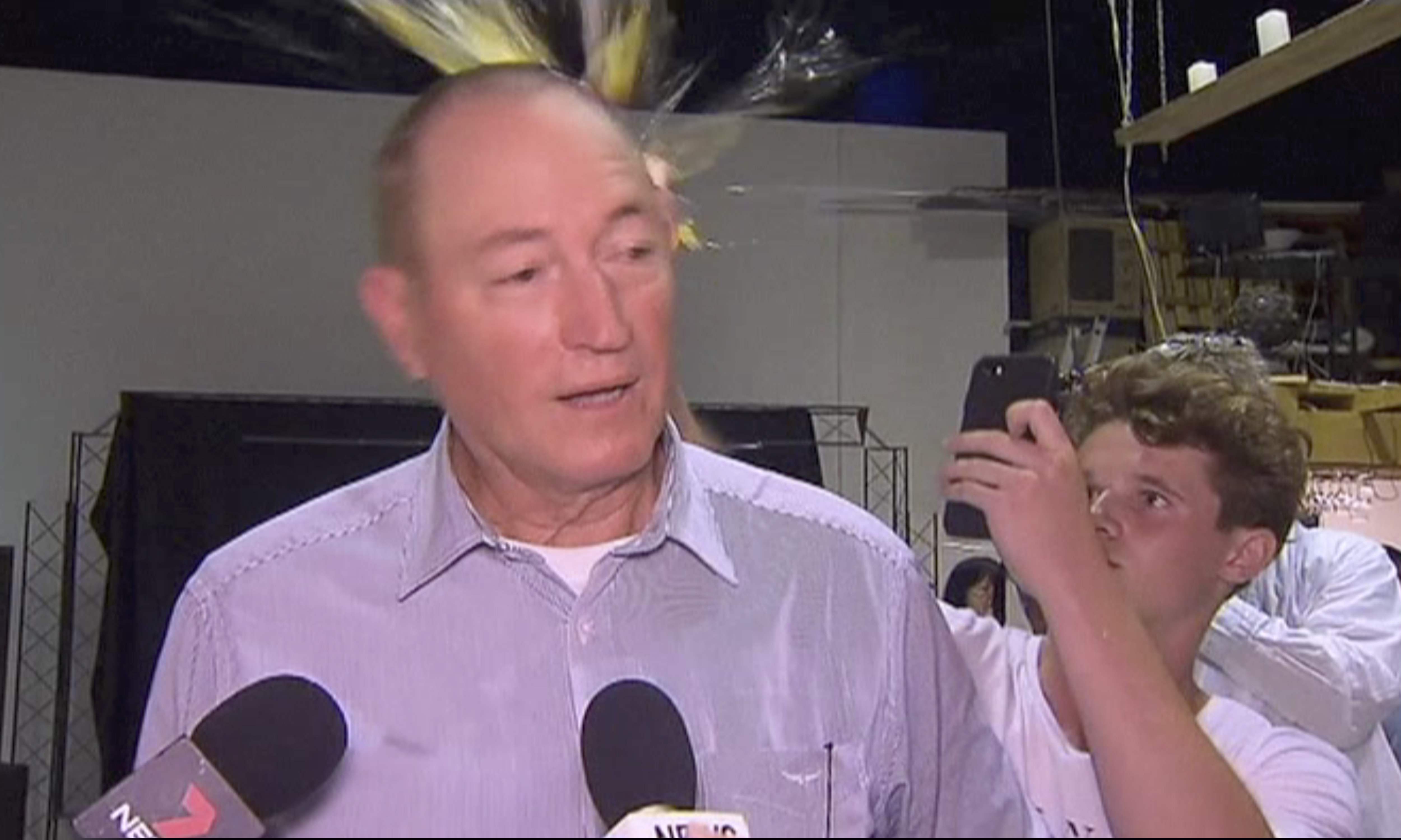 In this image made from video, a teenager breaks an egg on the head of Senator Fraser Anning while he holds a press conference, Saturday, March 16, 2019, in Melbourne, New Zealand. Following the mass shootings on Friday, Anning came under sharp criticism over tweets including one that said: “Does anyone still dispute the link between Muslim immigration and violence?”