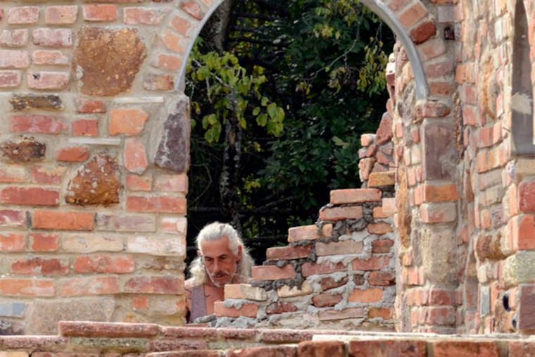 Philadelphia artist Jeff Tirante works on a wall in the under-construction Palace of Depression in Vineland. The original Palace was made of junk by the eccentric George Daynor, a former Alaska gold miner.
