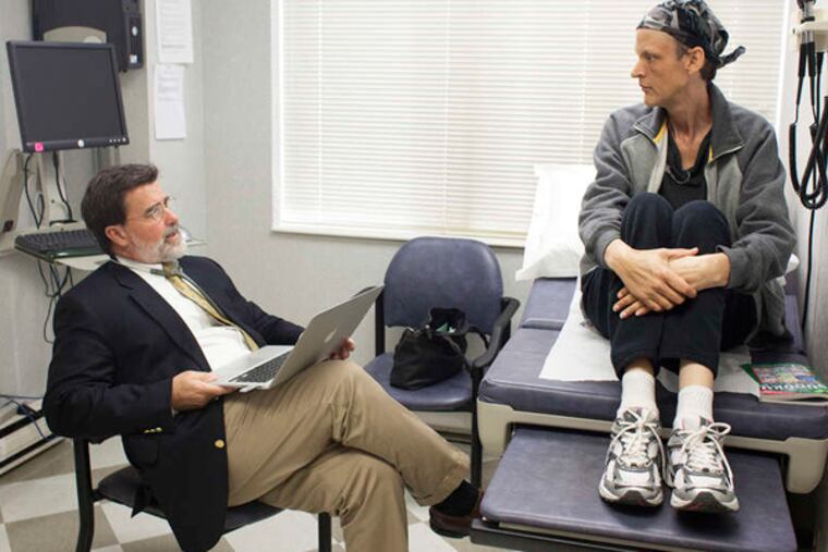 Oncologist John Sprandio with patient Michelle Rosado of Clifton Heights at his practice beside Delaware County Memorial Hospital. After three years of reorganizing, insurers are just starting to pay differently, allowing the group’s eight doctors to share in the savings they’re creating. ED HILLE / Staff Photographer