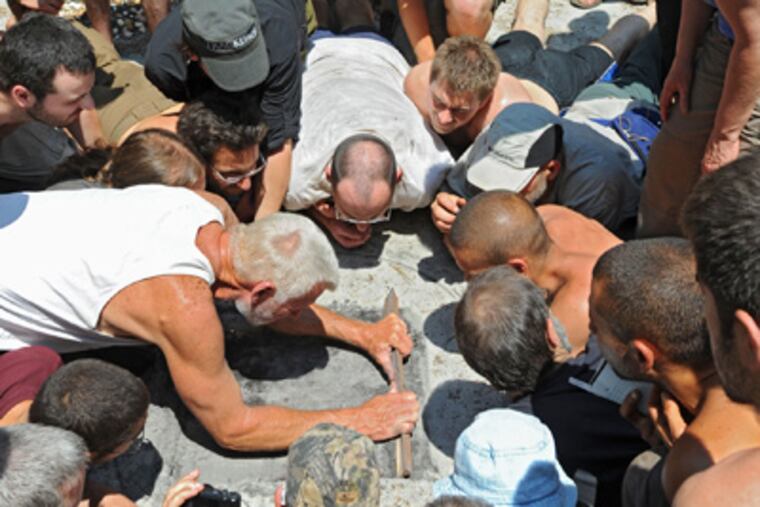 Surrounded by students, Tom Brown Jr. (center left) demonstrates "old-growth tracking." (Clem Murray / Staff Photographer)