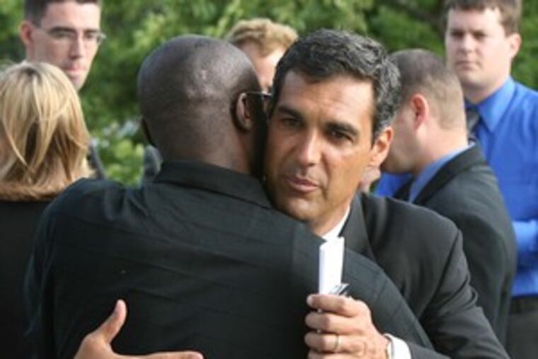 Villanova coach Jay Wright hugs former Wildcats player Jonathan Haynes before service.
