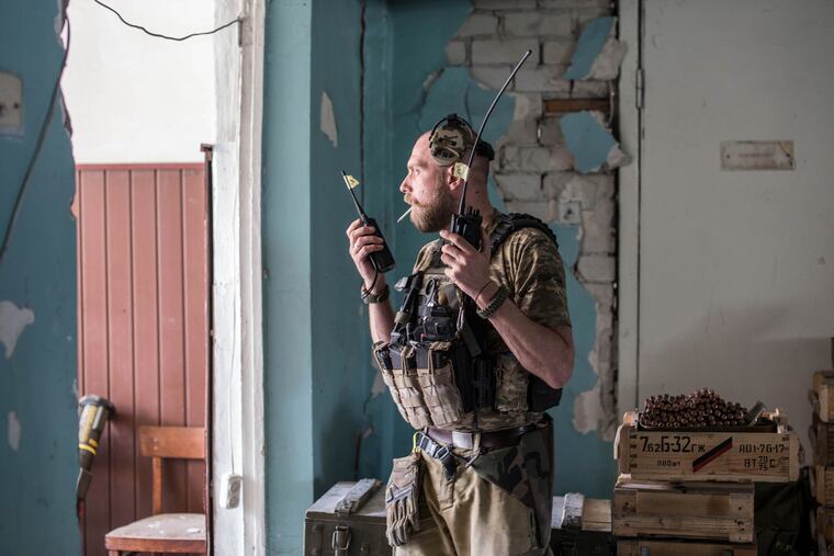 A Ukrainian soldier holds radios during heavy fighting on the front line in Severodonetsk, the Luhansk region, Ukraine, Wednesday, June 8, 2022.