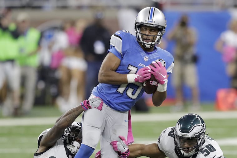 Detroit Lions' wide receiver Golden Tate catches the football past Eagles' free safety Jalen Mills (left) and middle linebacker Jordan Hicks late in the fourth-quarter on Sunday, October 9, 2016 in Detroit. YONG KIM / Staff Photographer