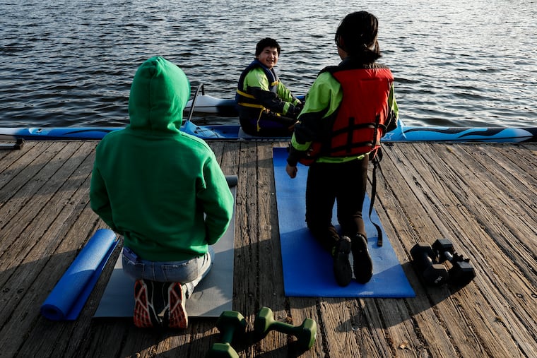 Tha Oo (center), 17, talks with Kat Miles (left), 18, and Joy Chen, 17, at FDR Park on Tuesday. Discovery Pathways, a nonprofit that tries to connect Philadelphia youths to nature, has been training young people in dragon boat racing since 2022. Five Discovery Pathways teens have been invited to try out for the national team.