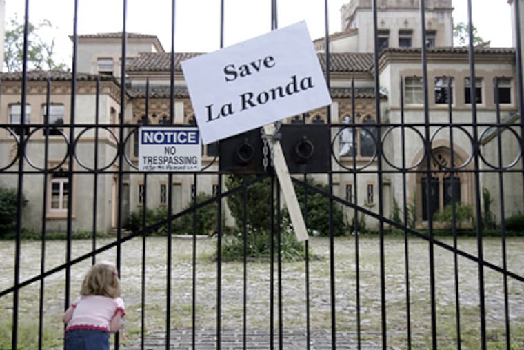 Devon Mattox, 4, of Havertown, views La Ronda through its fence, next to a “Save La Ronda” sign. (Akira Suwa / Staff Photographer)