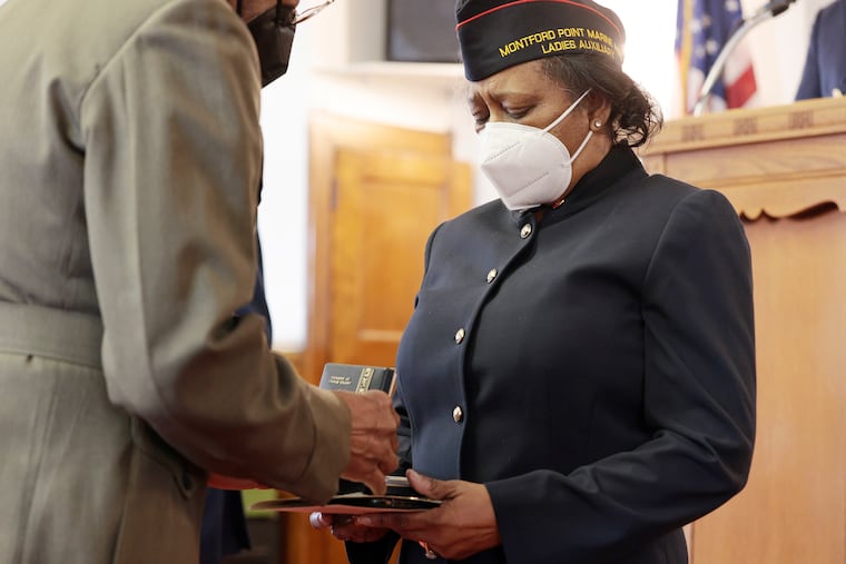 Marine Corps Retired Major General Clifford L. Stanley (left) presents Sandra Fuller with a Purple Heart for Cpl. Alfonzia Kirven (her uncle) at the Calvary Gospel Chapel in Philadelphia Saturday.