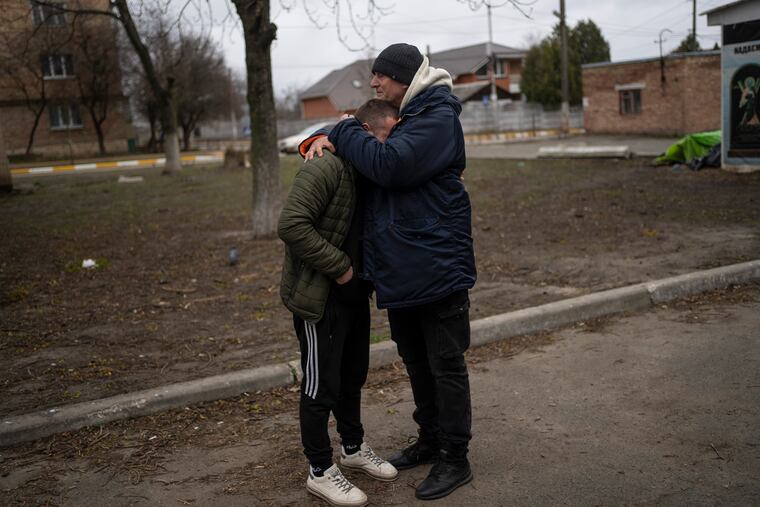 The father and a friend of Anatoliy Kolesnikov, 30, who was killed by Russian soldiers in his car trying to evacuate from Irpin, mourns his death while waiting outside the morgue in Bucha, in the outskirts of Kyiv, Ukraine, Wednesday , April 13, 2022.