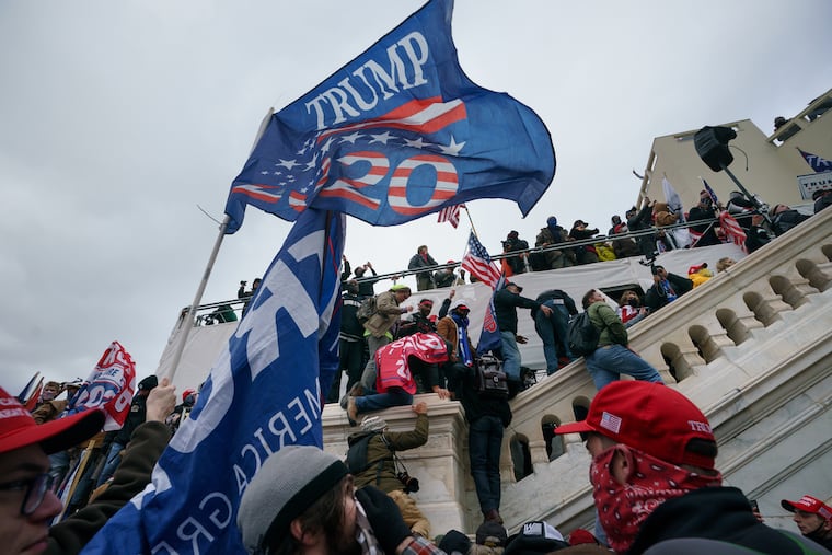 Rioters scale a wall at the U.S. Capitol building on Jan. 6, 2021.