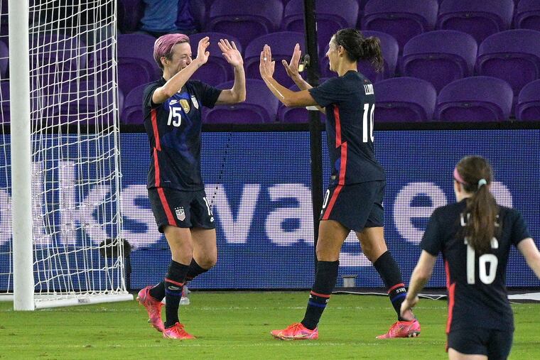 Megan Rapinoe, left, celebrates with Delran's Carli Lloyd after scoring her second goal against Argentina.