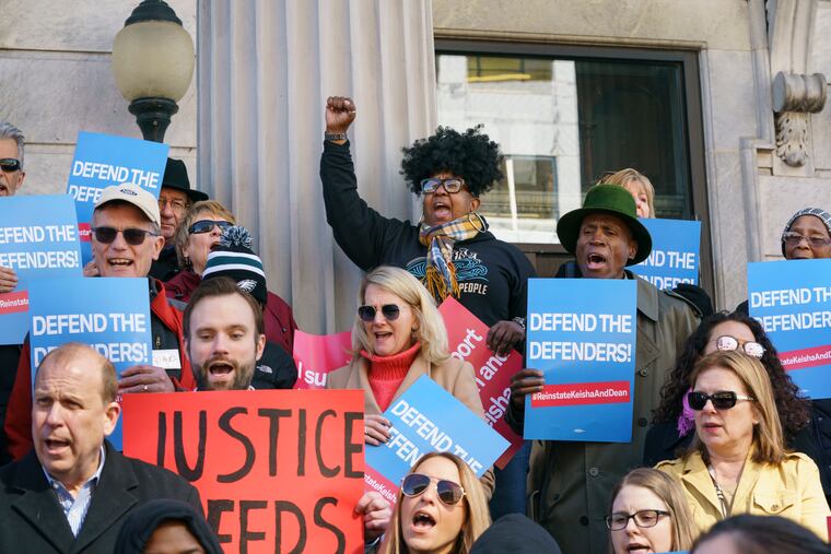 Adrian Aiken, back center, raises her fist as protesters, including state Sen. Daylin Leach, bottom left, gather on the steps of the Montgomery County courthouse to protest the recent firings of top public defenders Dean Beer and Keisha Hudson.