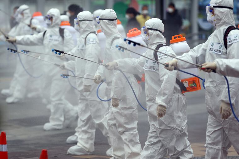 Army soldiers wearing protective suits spray disinfectant to prevent the spread of the new coronavirus at the Dongdaegu train station in Daegu, South Korea, Saturday, Feb. 29, 2020.