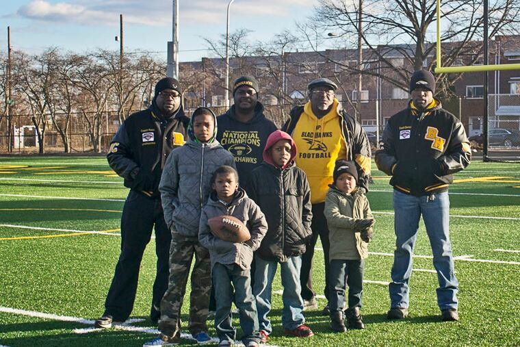 Keon Savoy, defensive coordinator, Jeff Days, president, Don Richardson, director, and Derrick Williams, head coach, stand in the new Blackhawks field. Philadelphia, PA. November 28, 2014. Daily News Staff / Randi Fair
